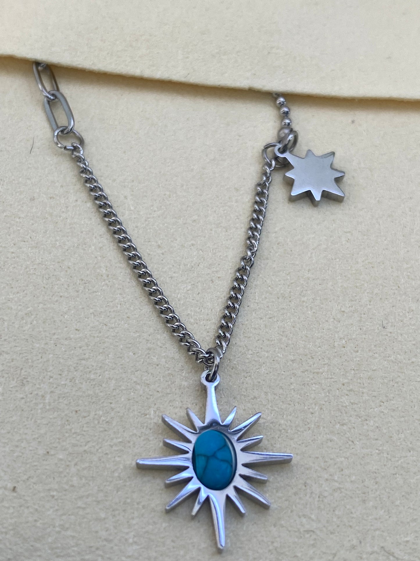 Colar prateado com pingente de pedra azul